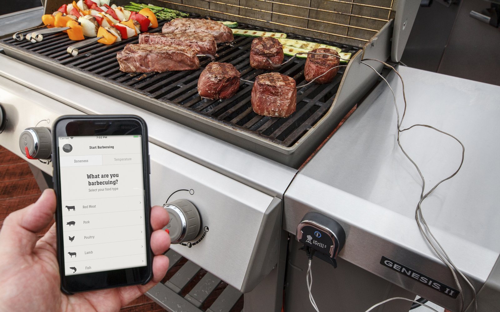 Teploměr iGrill 3 na grilu Genesis se sondami v mase a aplikací v telefonu